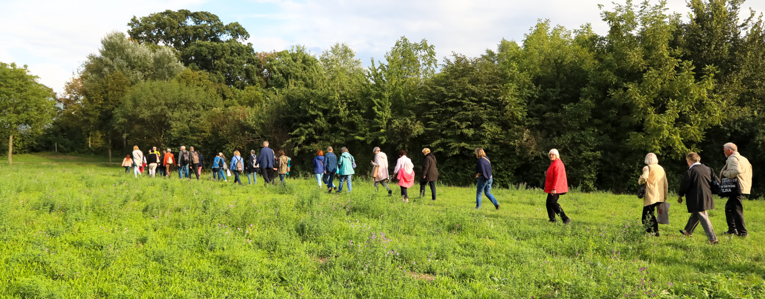 Personen wandern in einer herbstlichen Landschaft